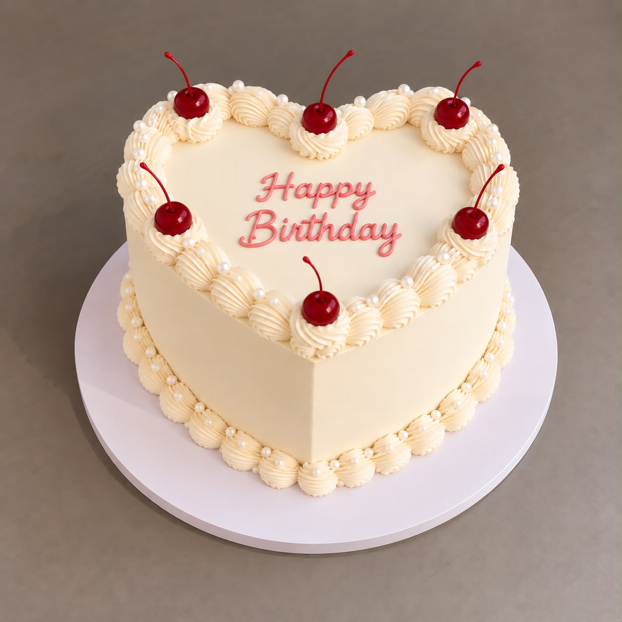 A custom heart-shaped KuRiMu cake with piped Happy Birthday lettering